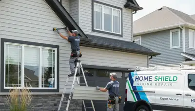 Technician repairing cracked vinyl siding on home exterior in Cleveland, OH